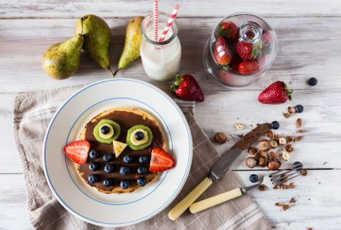 Top view on pancakes with the owl of berries