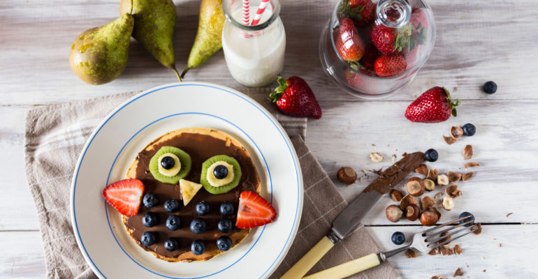 Top view on pancakes with the owl of berries